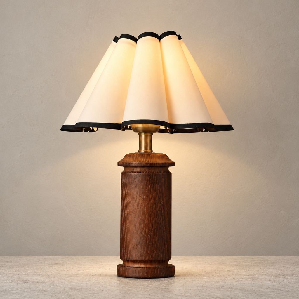 Morivelle pleated shade wood table lamp lit on a warm stone surface