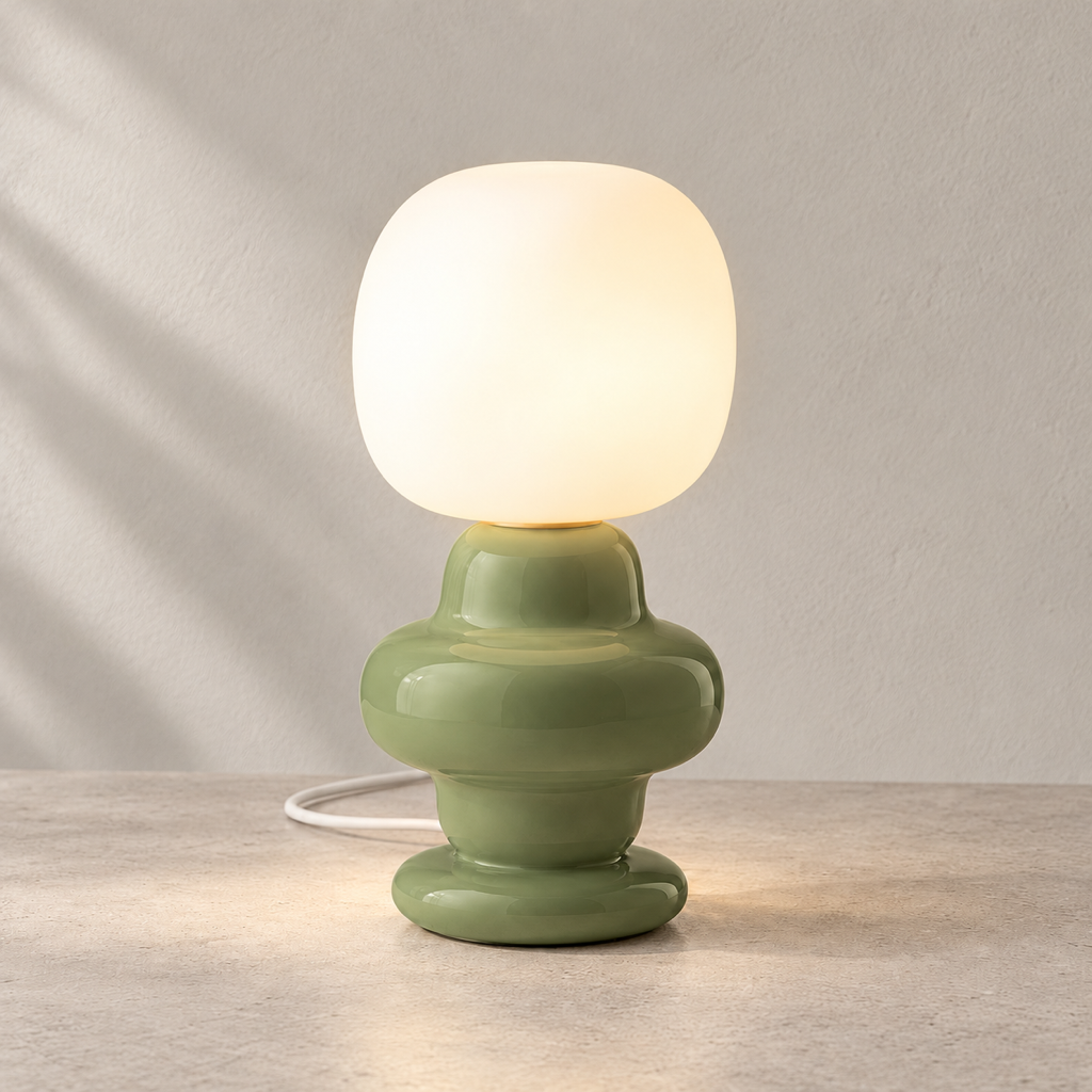 Marunelle grass-green ceramic and glass table lamp lit on a warm neutral surface