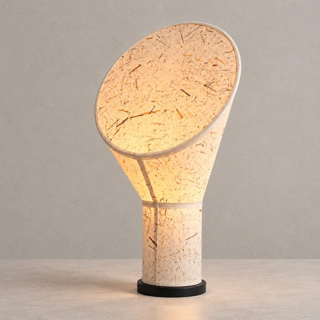 Serevane sculptural fiber paper table lamp lit on a warm stone surface