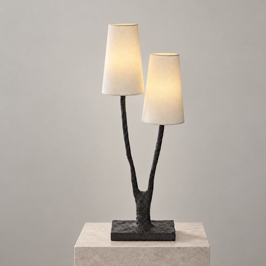 Noirbough sculptural black copper branch table lamp illuminated against a warm neutral wall