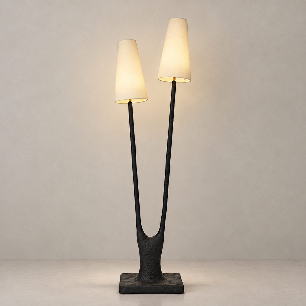 Noirbough sculptural black copper branch floor lamp illuminated against a warm neutral wall