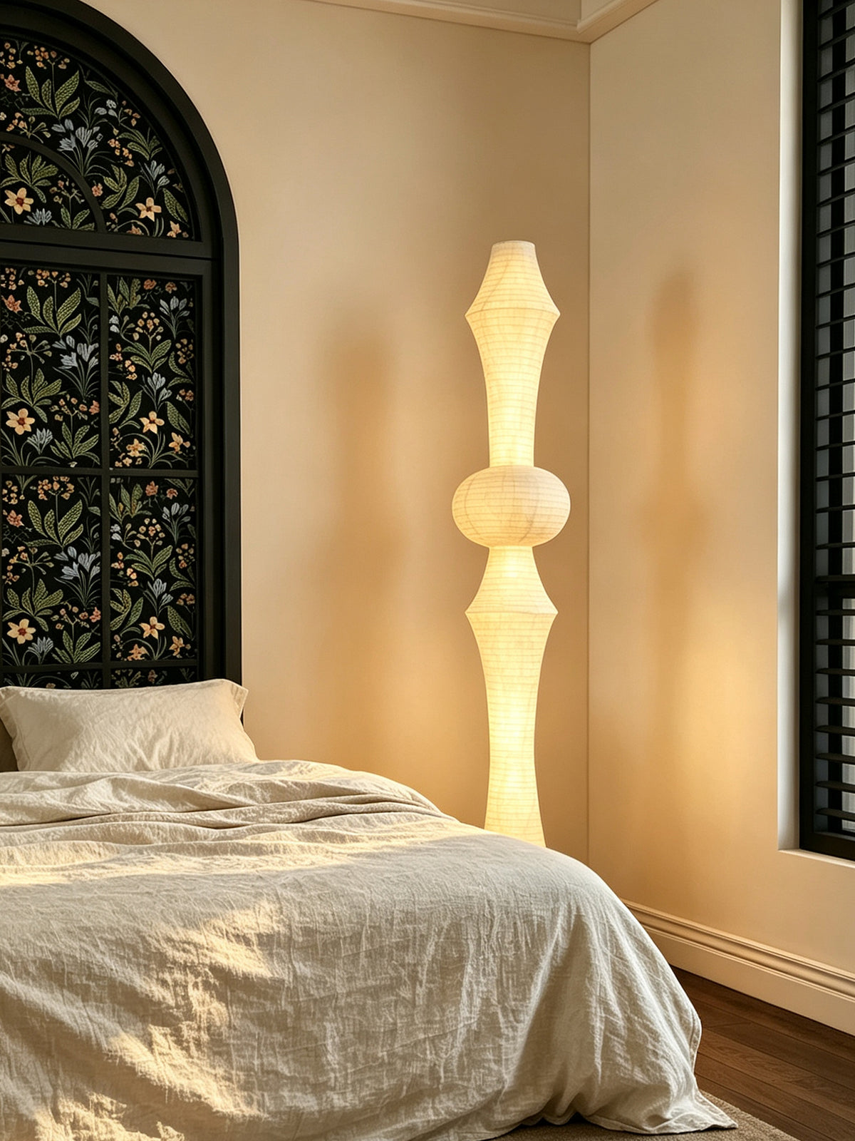 ARDEN LUME Orlithane silk floor lamp Design A switched on beside a linen bed in a warm bedroom.