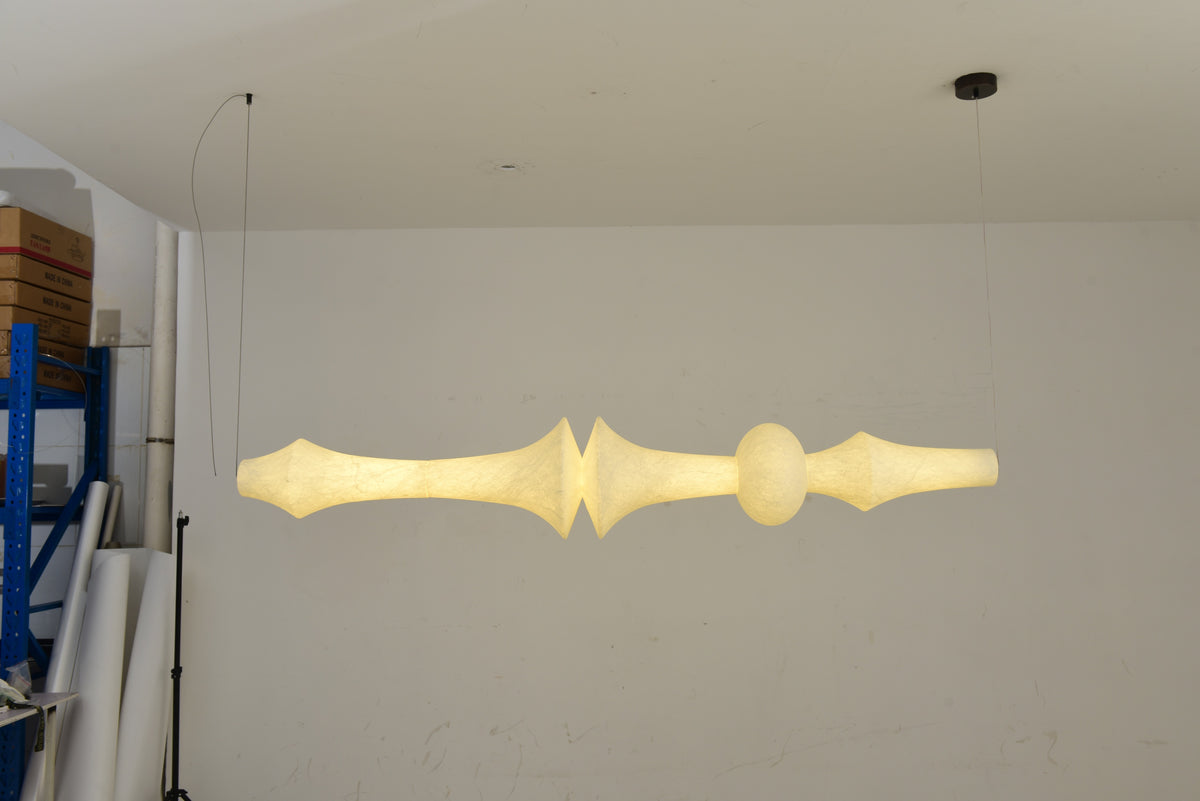 ARDEN LUME Orlithane linear pendant, Design F, actual illuminated product photograph showing the paired flared sections and complete body.
