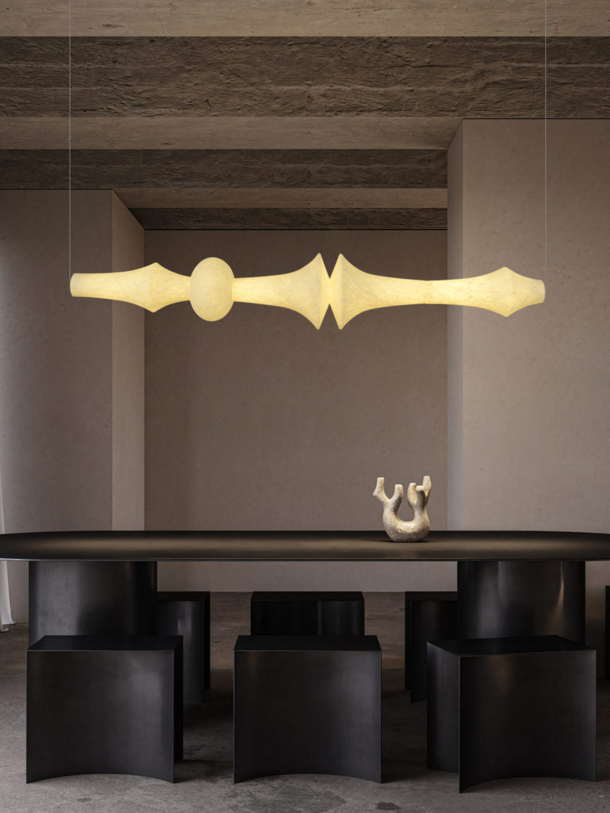 Orlithane linear pendant, Design F, illuminated above a dark dining table in the original textured-stone interior scene.