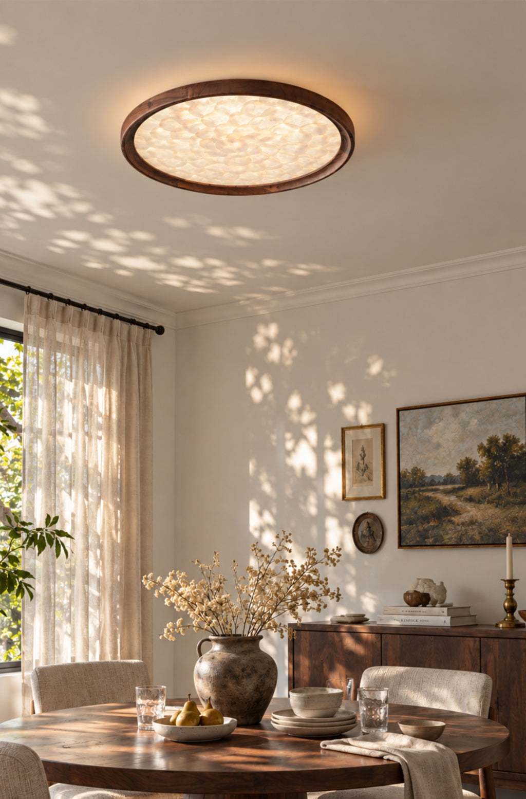 Walnut and shell ceiling light above a wood dining table beside a sheer-curtained window