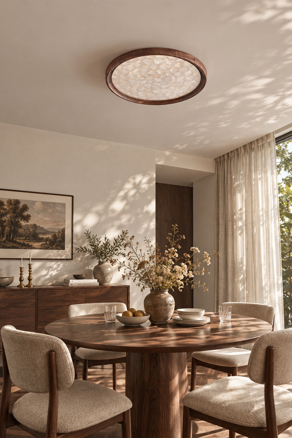 Walnut and shell flush mount above a round dining table in a sunlit interior