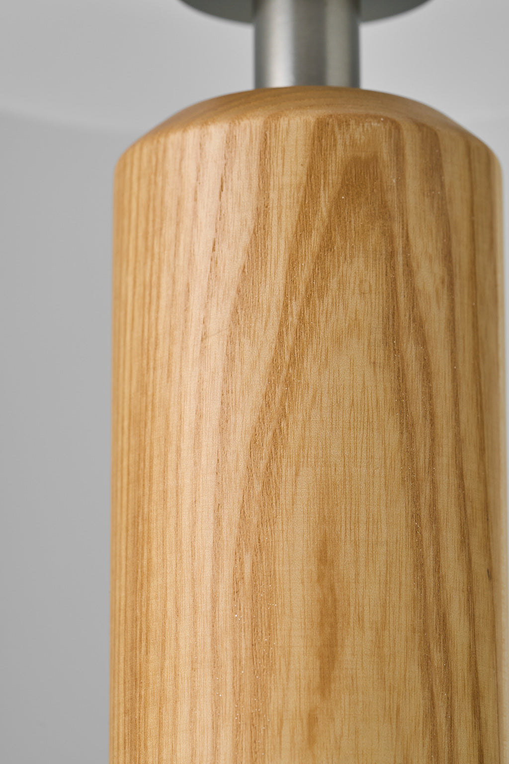 Close-up product photograph of the natural ash grain and silver neck of Tavellen table lamp