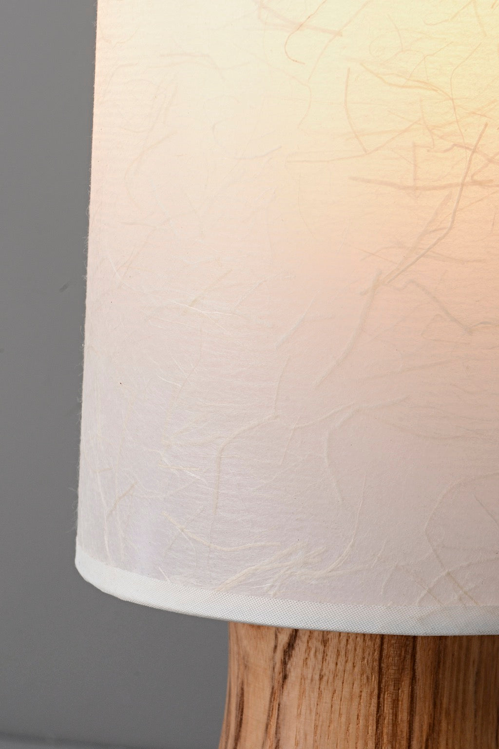 Tavrane natural ash wood and fabric table lamp, detail, light on