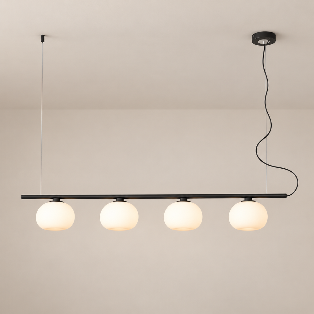 Black four-globe glass linear pendant against a taupe ceiling, turned on