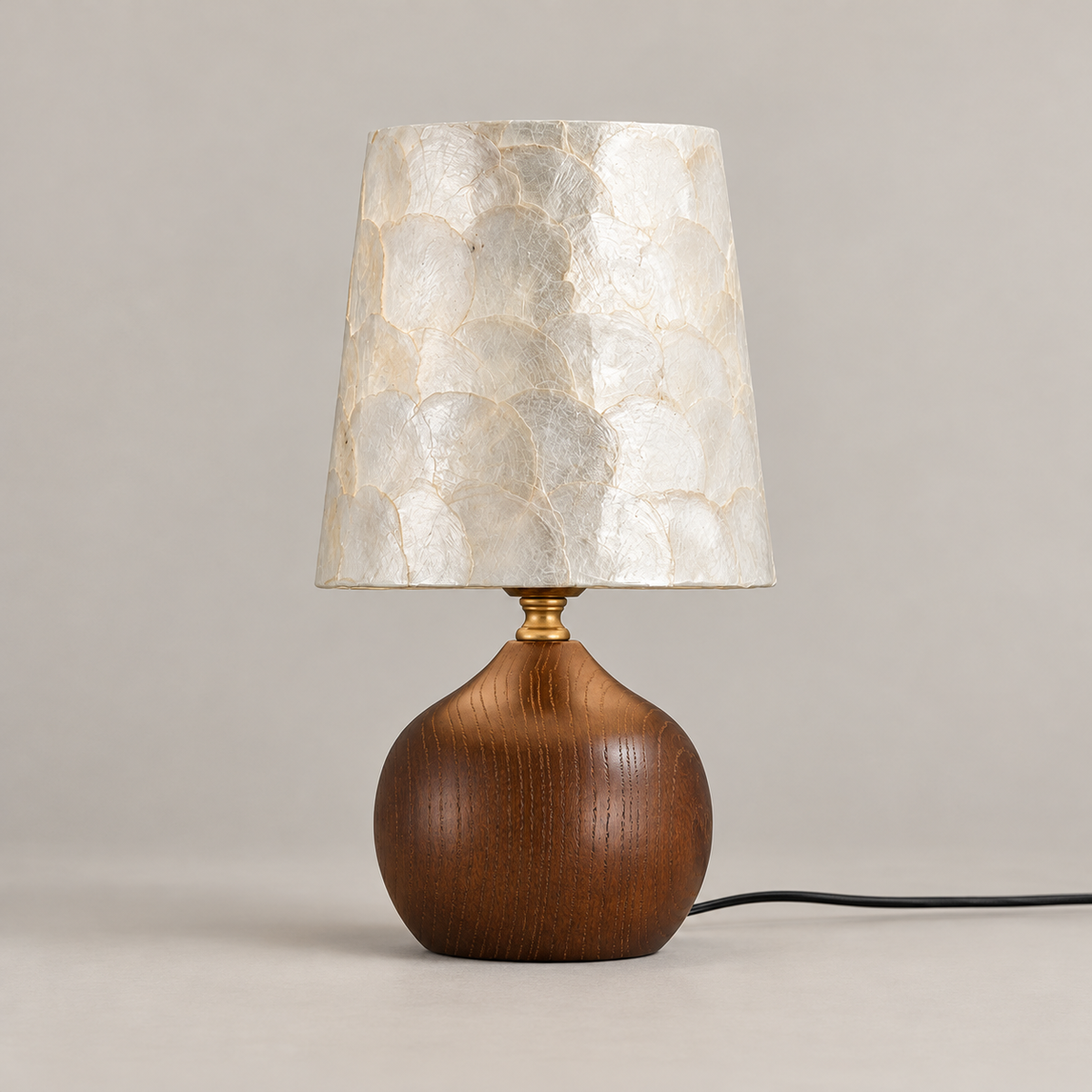 Shell and ash wood table lamp in walnut finish, switched off, on a warm greige background