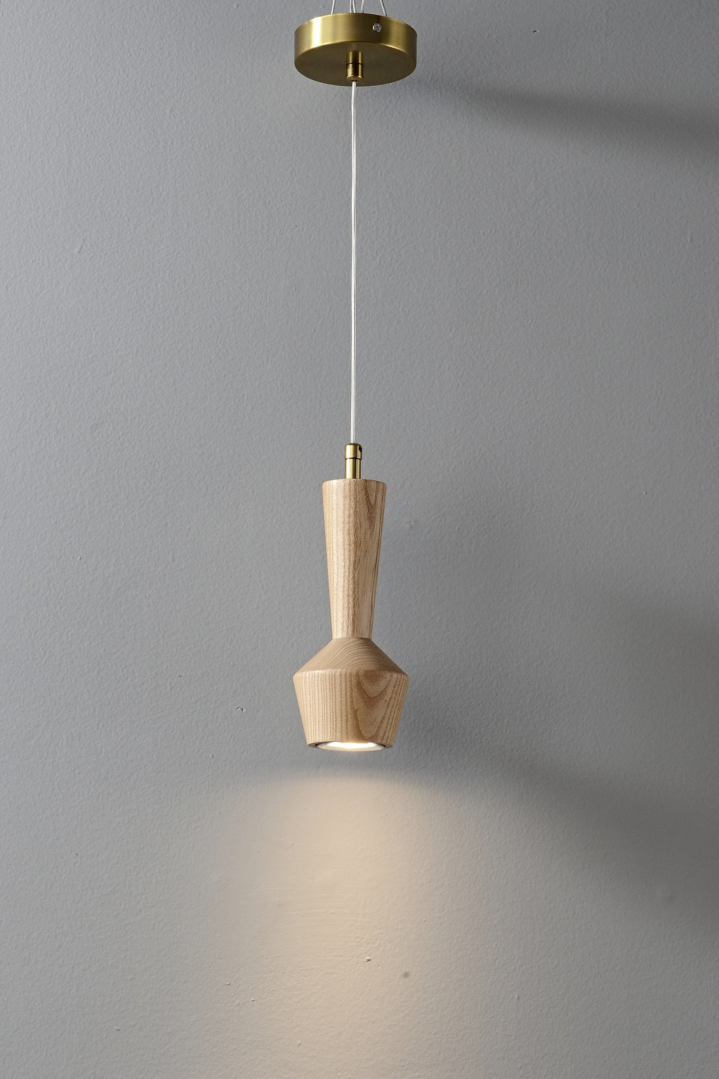 Actual ash wood pendant showing its warm downward LED light