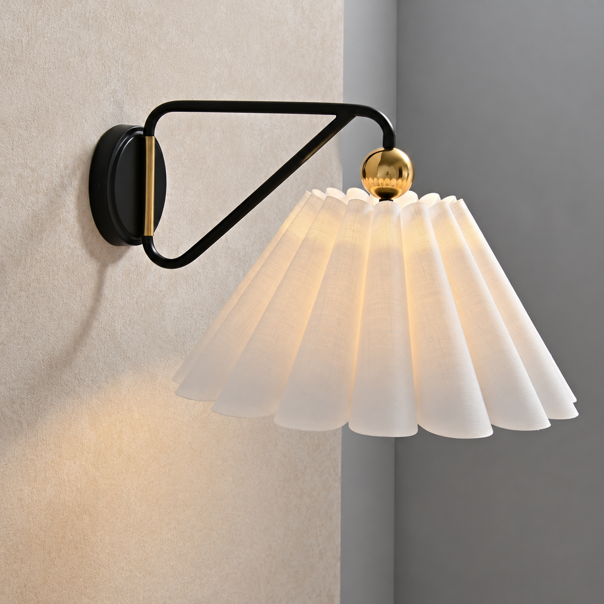 Side view of the fabric wall sconce showing its looped black arm and circular backplate