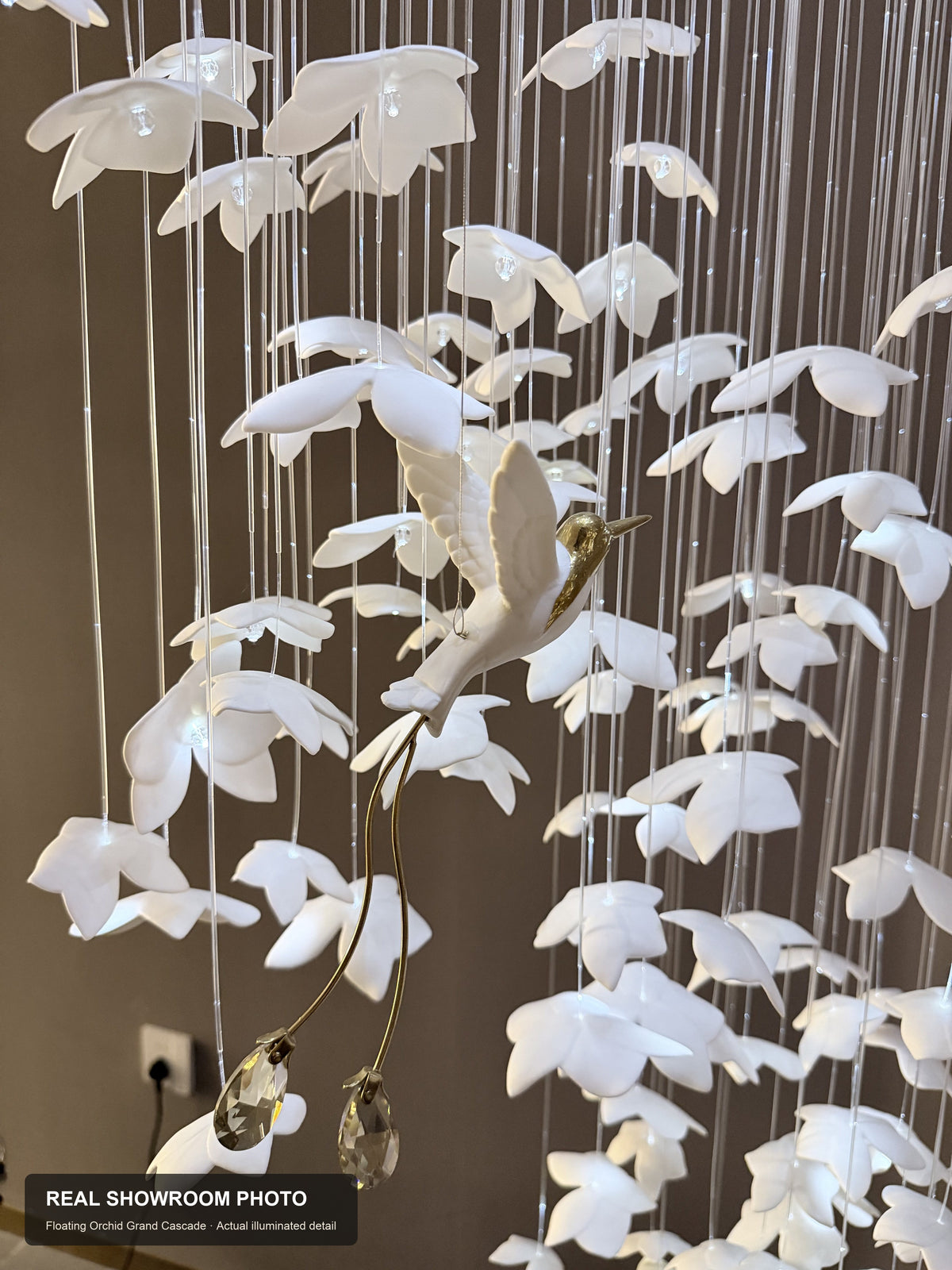 Floating Orchid Ceramic Grand Cascade Chandelier — real showroom photo, ceramic bird and crystal drop detail