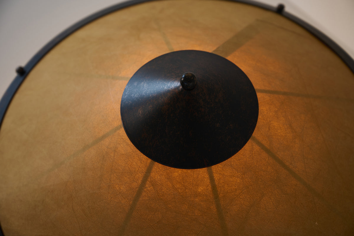 Warm-lit Tyvek paper shade and copper cap detail