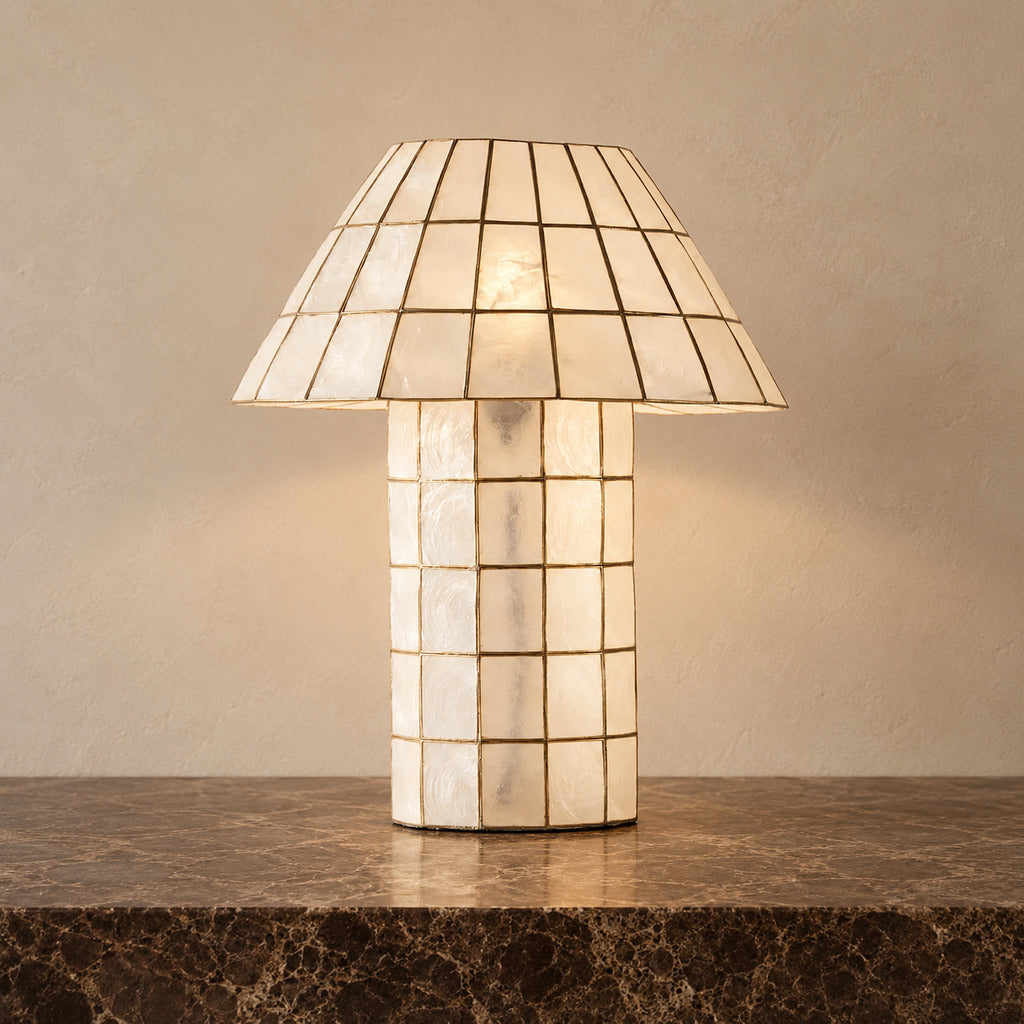 Ivorelle faceted lattice table lamp illuminated on a stone tabletop against a warm neutral wall