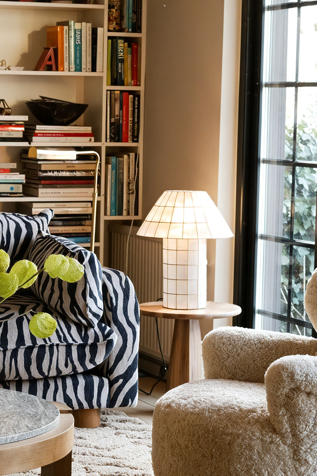 Ivorelle lattice table lamp glowing beside a sofa in a contemporary living room