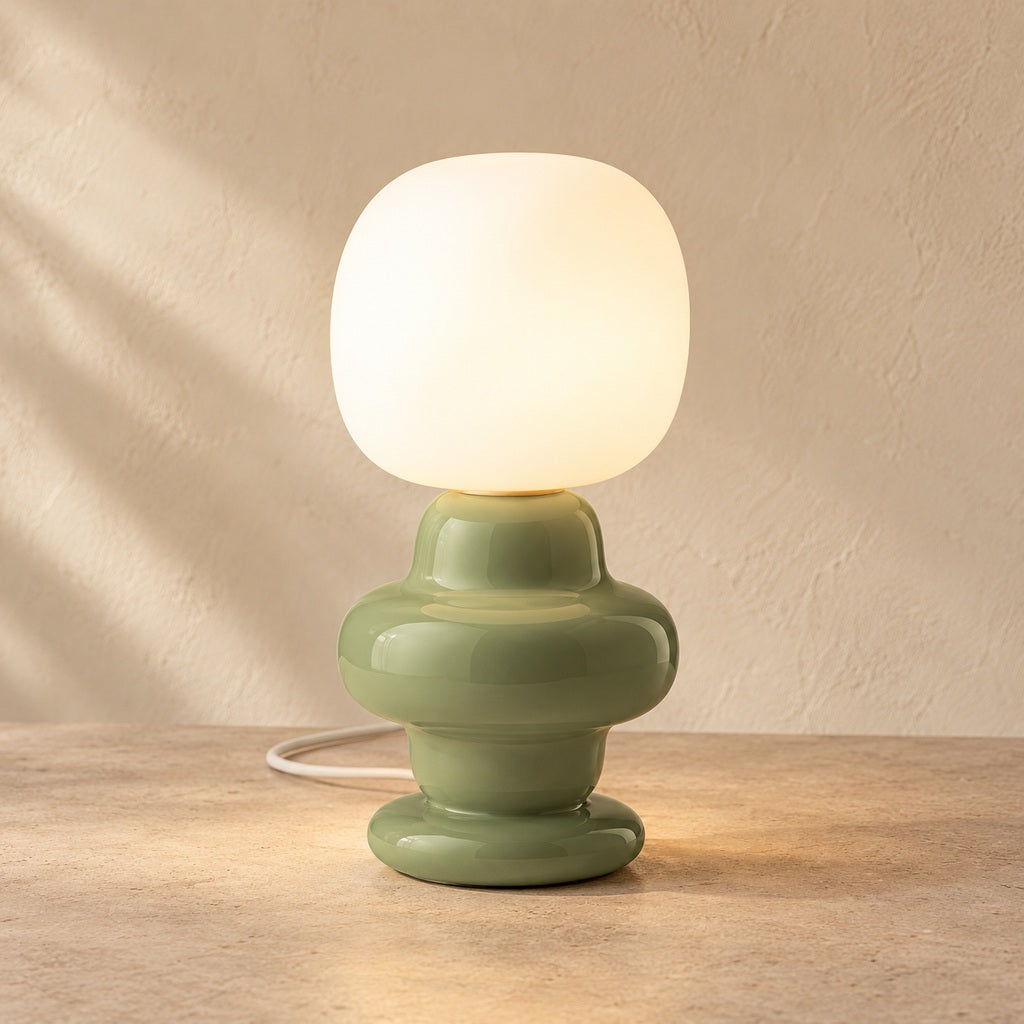 Marunelle grass-green ceramic and glass table lamp lit on a warm neutral surface