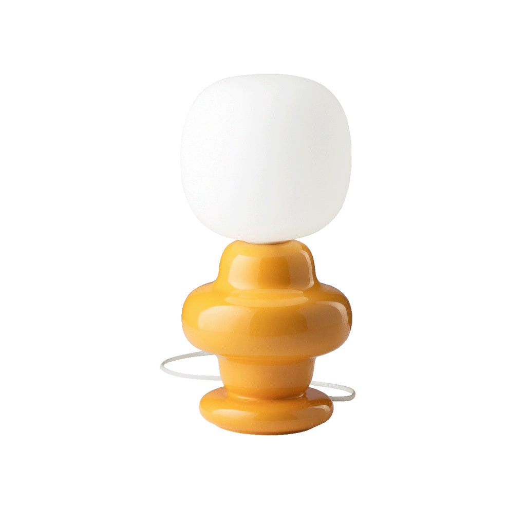 Marunelle yellow ceramic and glass table lamp on a white background