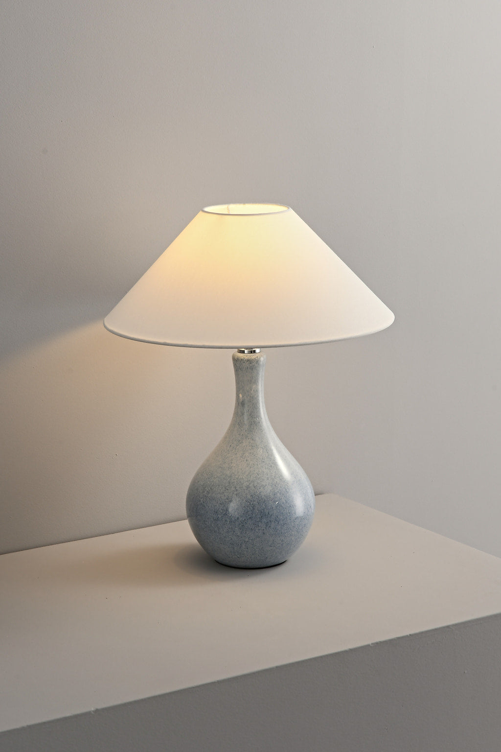 Mist-Blue glazed ceramic table lamp illuminated from an angled view