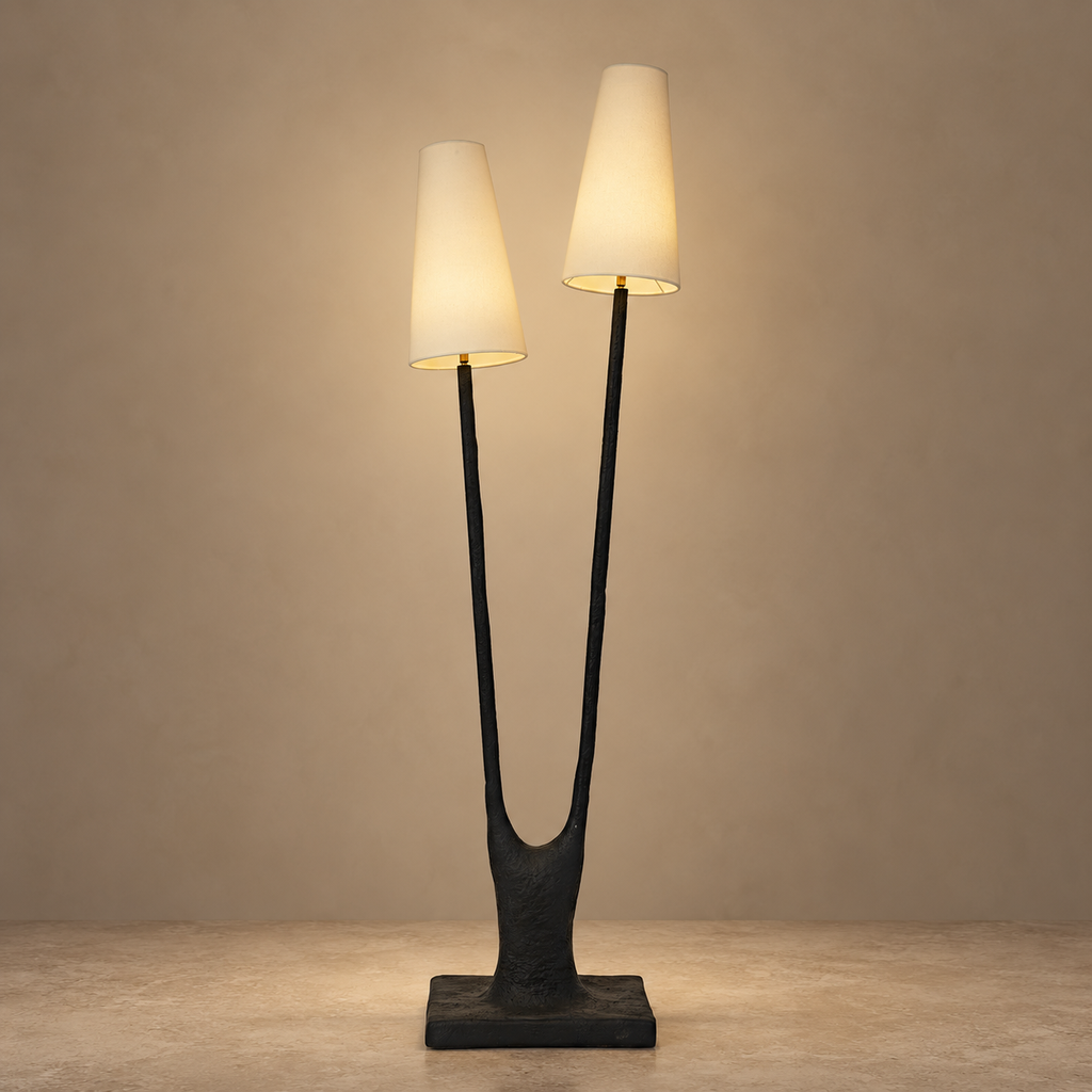 Noirbough sculptural black copper branch floor lamp illuminated against a warm neutral wall