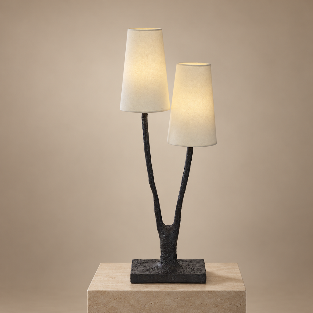 Noirbough sculptural black copper branch table lamp illuminated against a warm neutral wall
