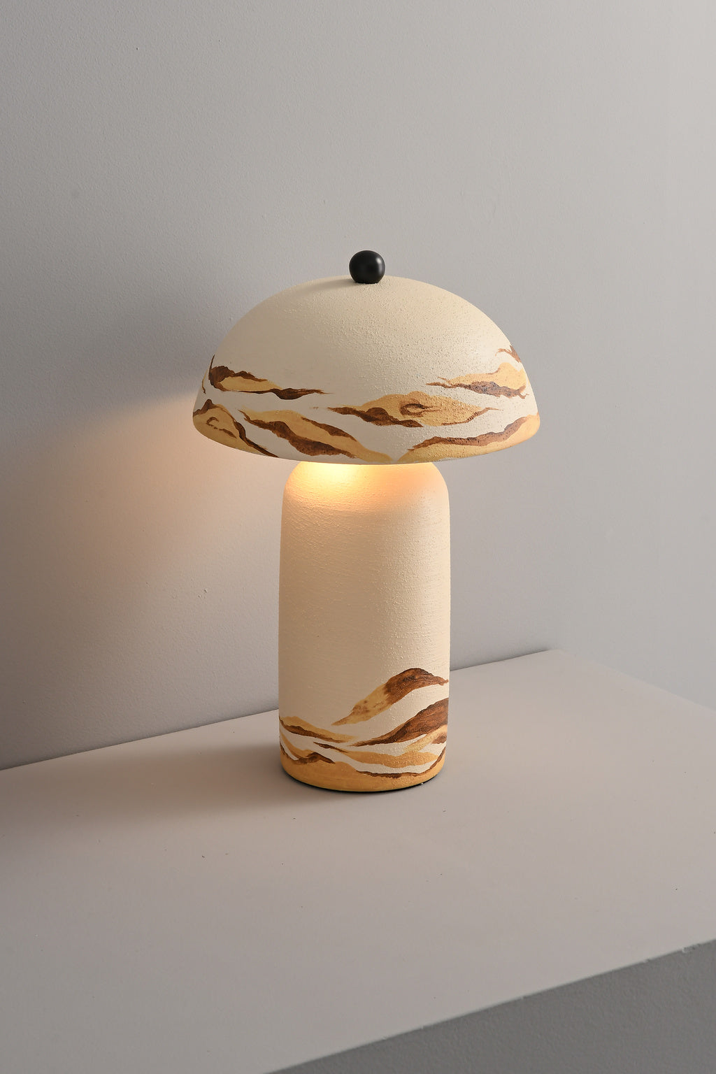Desert Ivory hand-painted ceramic table lamp lit in a real room