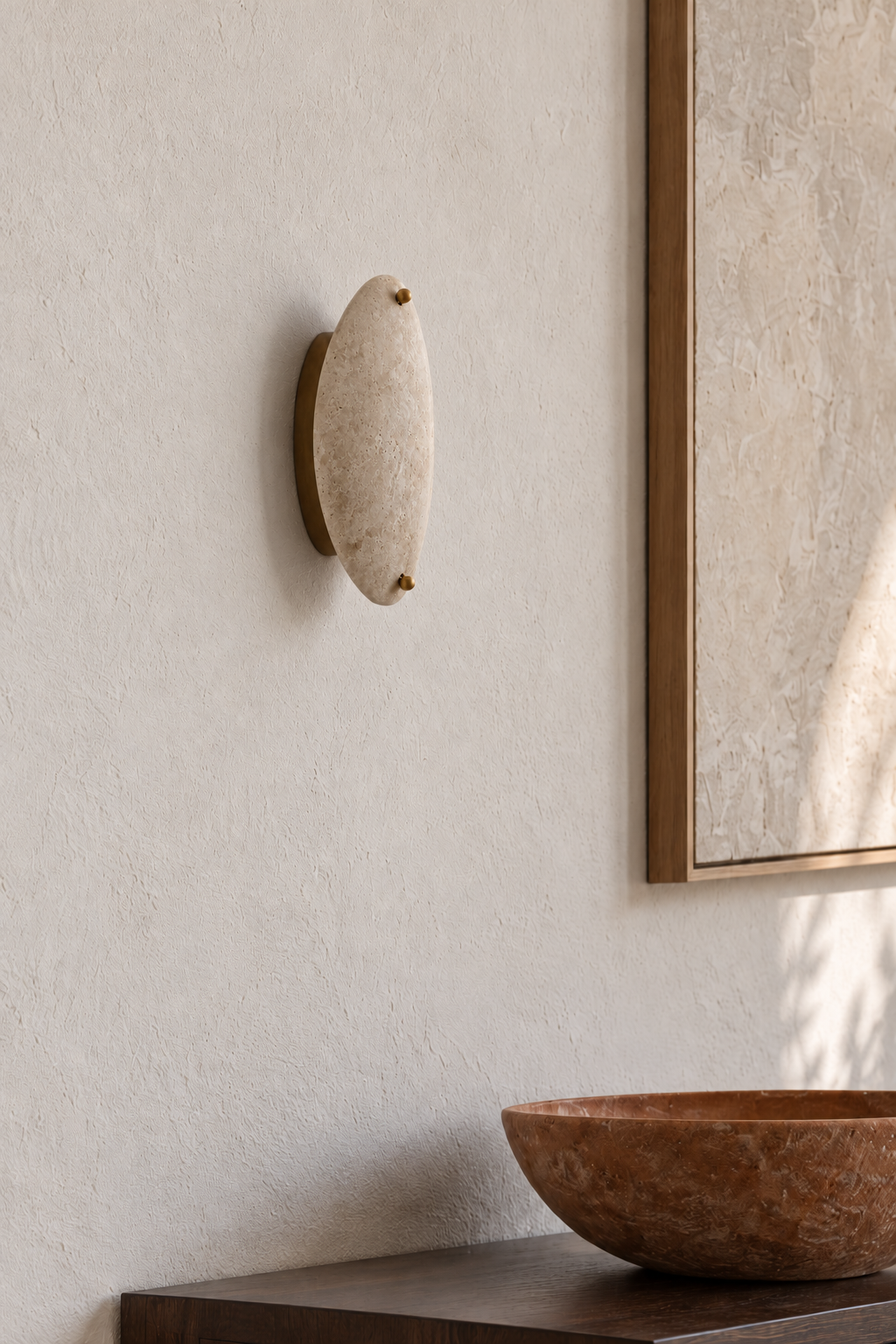 Close view of an unlit beige stone wall sconce and its mounting plate