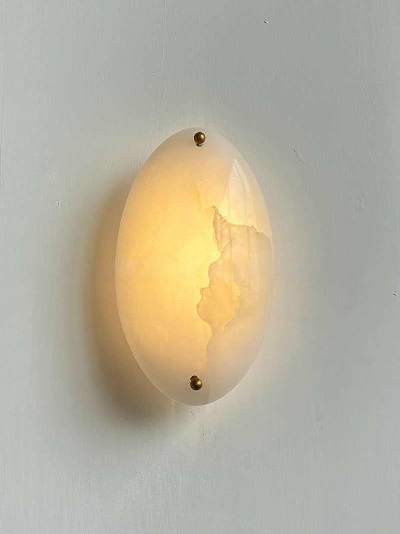 Real front view of the white stone wall sconce illuminated