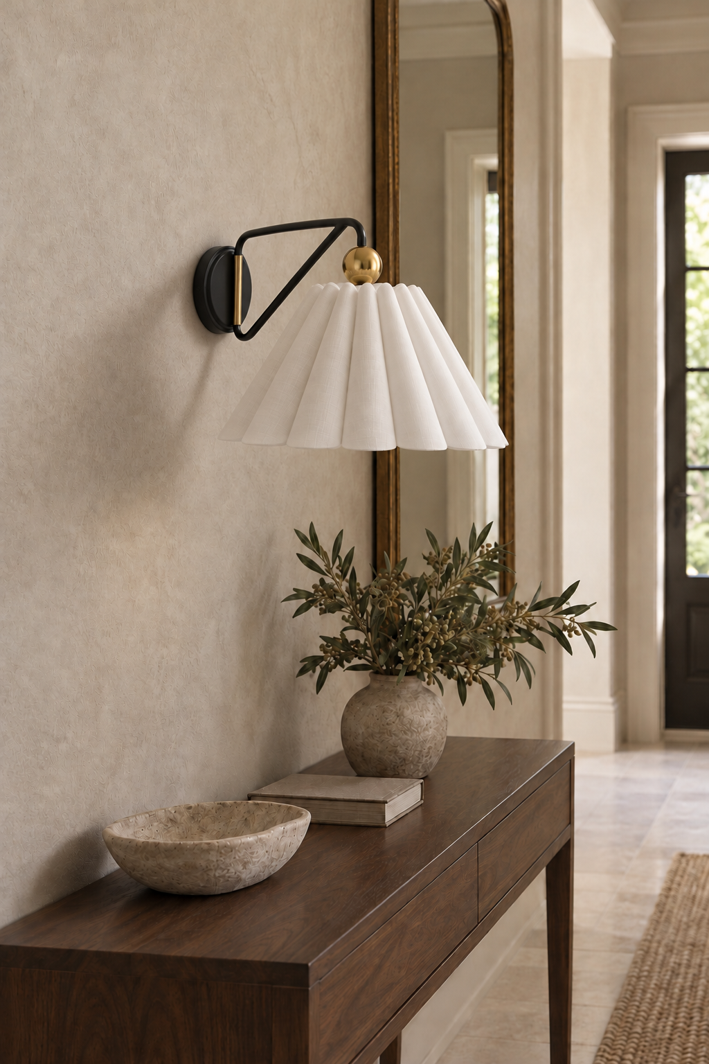 Unlit fabric wall sconce above a console in an entryway