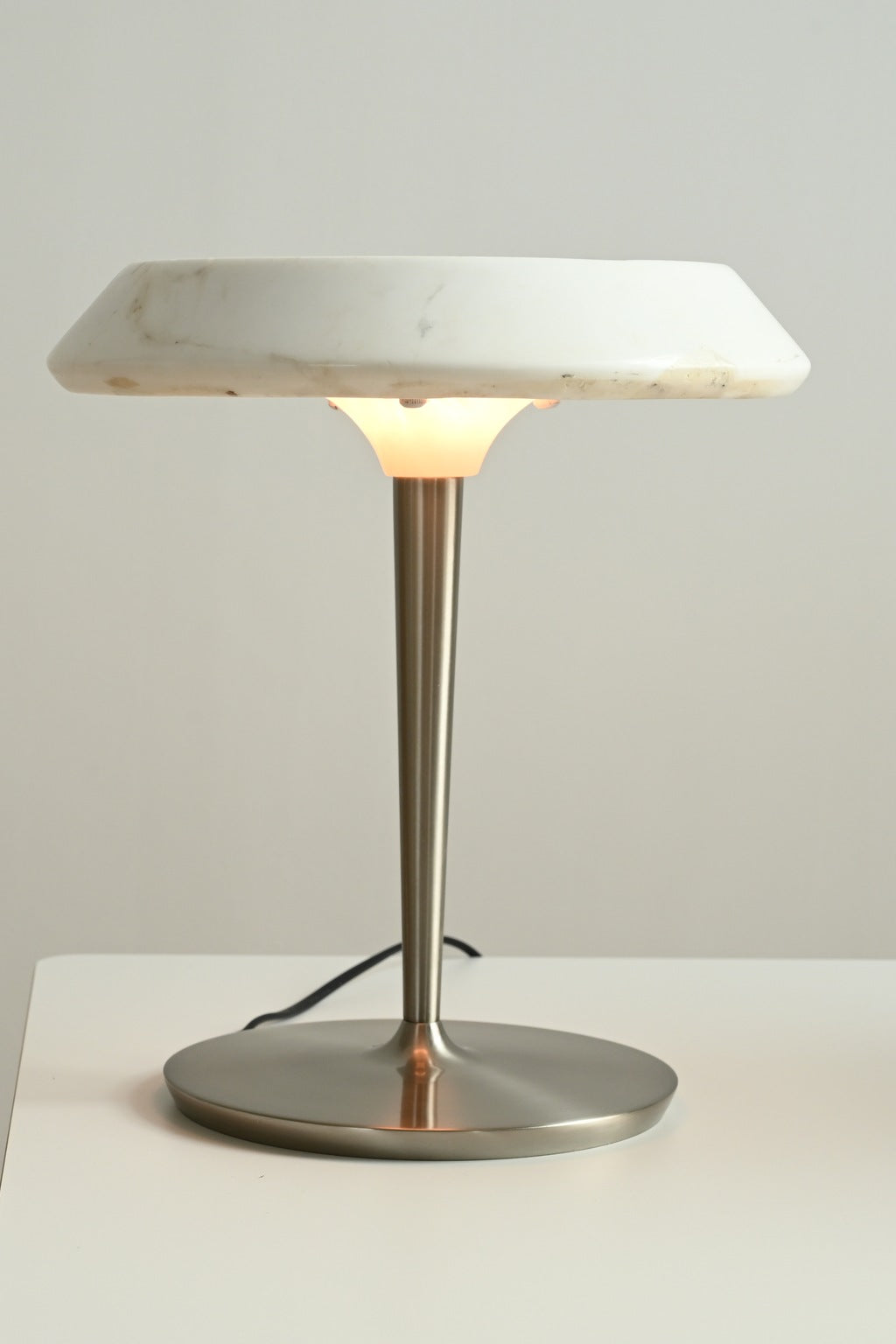 Solvenne Carrara white marble table lamp lit in a front studio view
