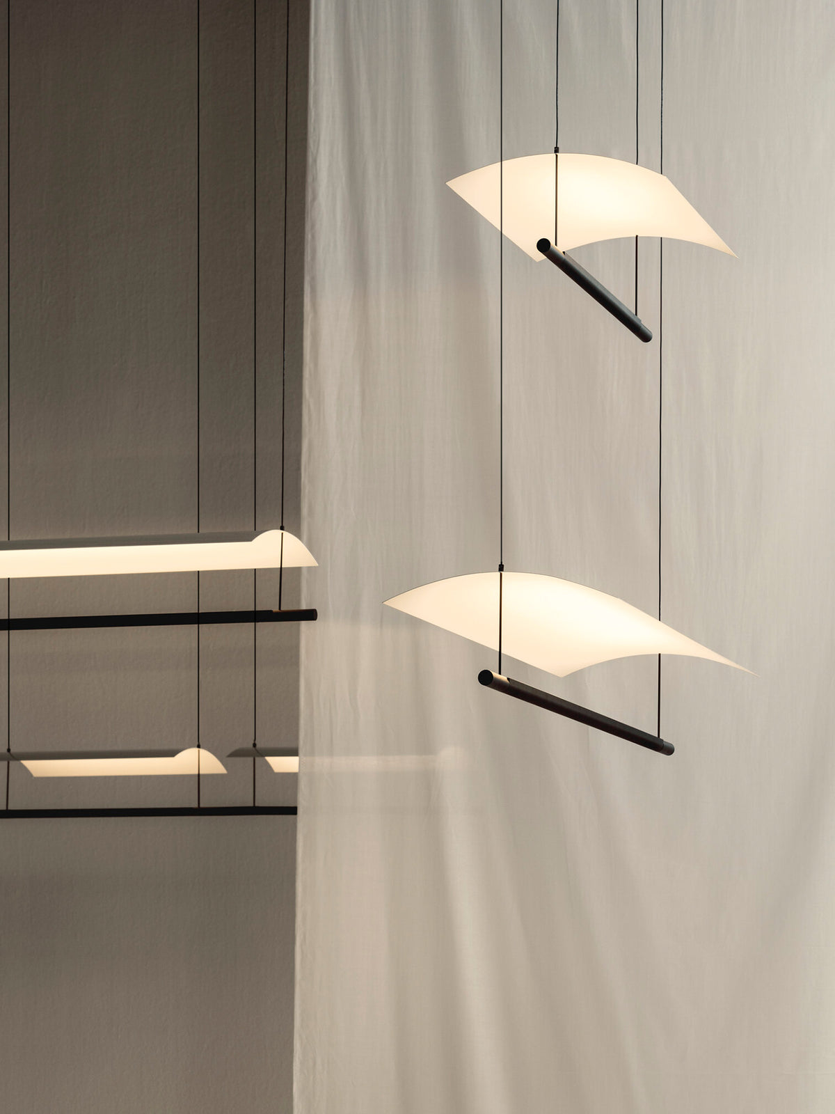 Veilane lighting collection, curved wing pendants in a display installation; fixtures sold separately
