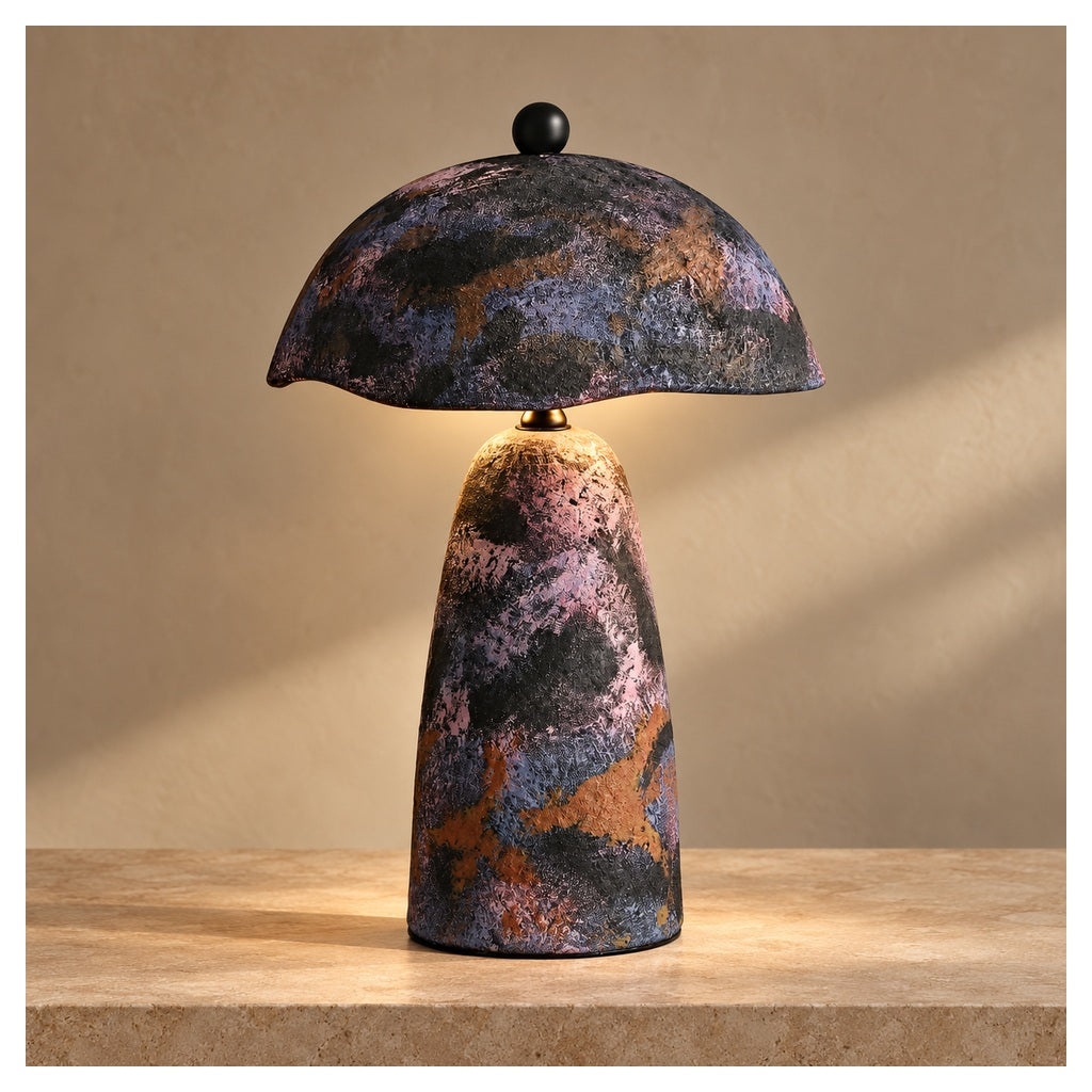 Velmurne hand-painted ceramic table lamp lit on a warm stone surface