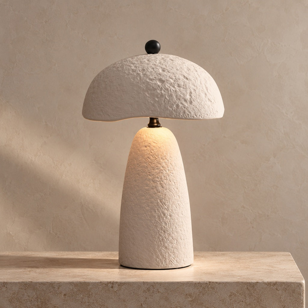 Velmurne textured white ceramic table lamp lit on a warm stone surface