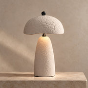 Velmurne textured white ceramic table lamp lit on a warm stone surface
