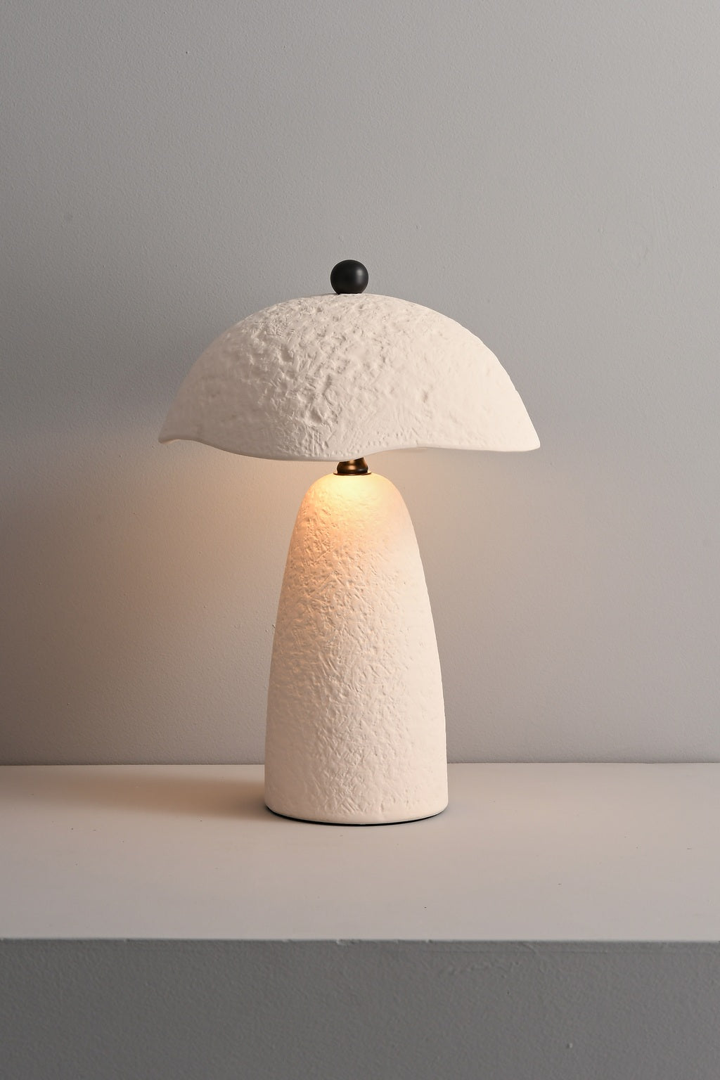 Velmurne white ceramic table lamp lit in a real studio