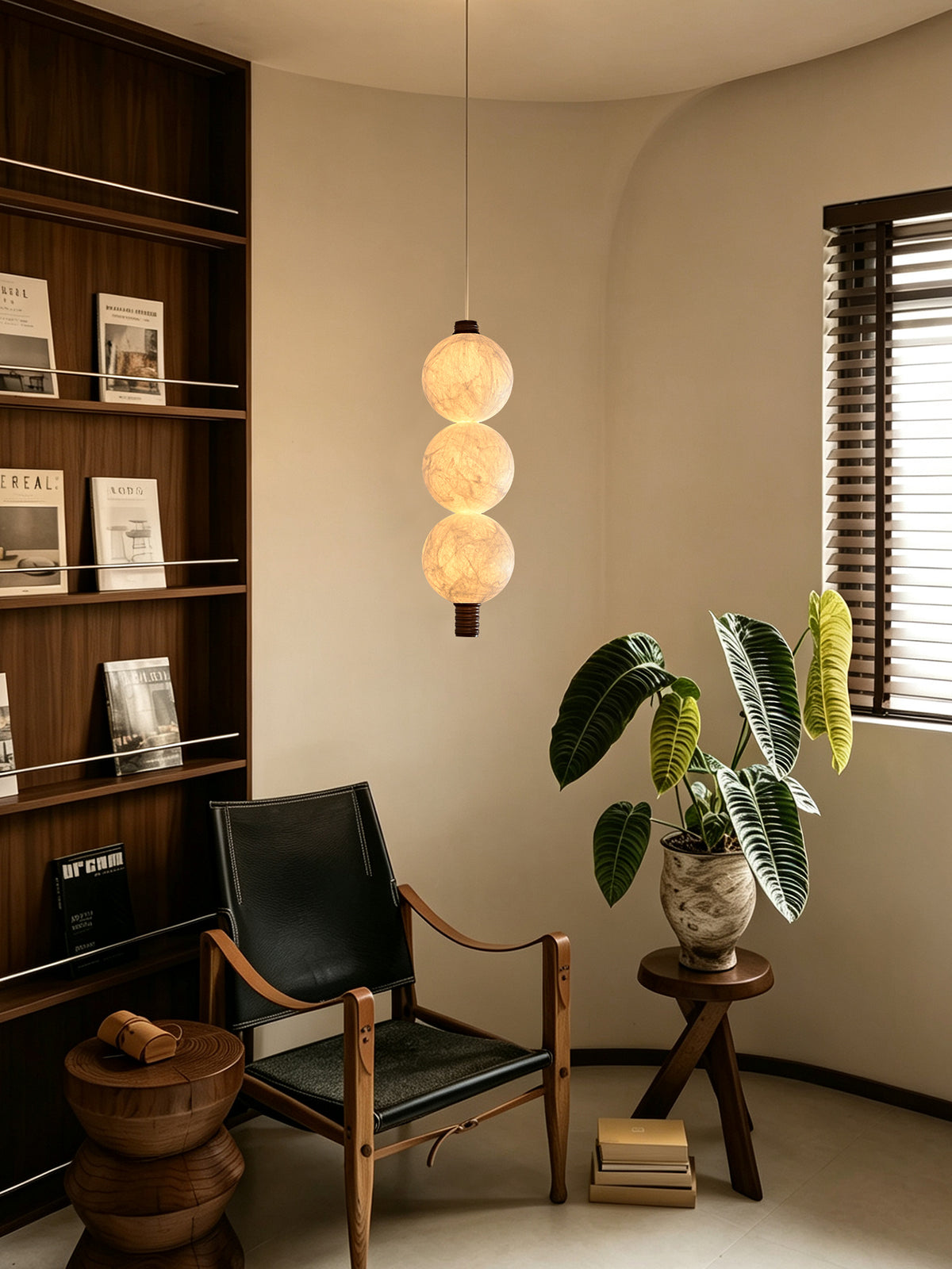 Three-globe natural mulberry silk vertical pendant with dark wood details, lit in a reading corner beside a bookcase
