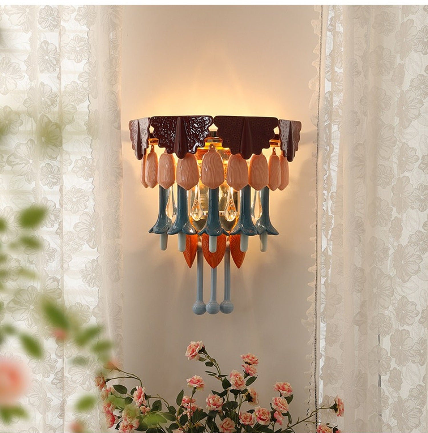 Colorful ceramic glass wall sconce styled with lace curtains and flowers