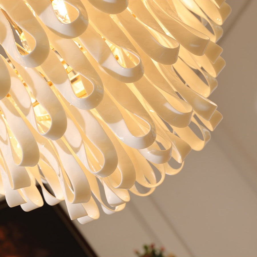 Close view of glossy ivory ceramic ribbon pieces on the flush mount chandelier
