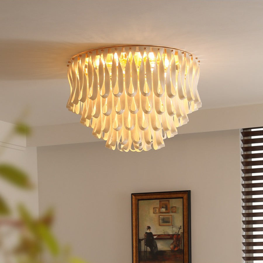 Warm lit flush mount ceramic ribbon chandelier in a room