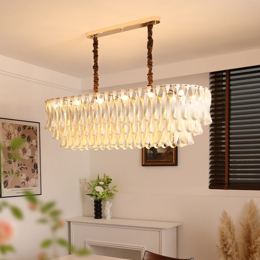 Warm lit linear ceramic ribbon chandelier in a dining room